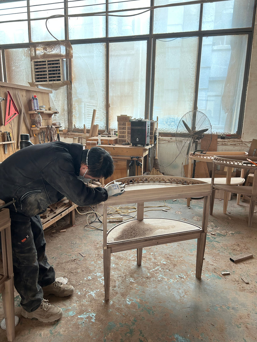Craftsperson working on the unfinished frame of the HEMUJI solid wood accent cabinet